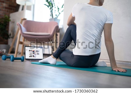oung sporty slim woman has internet video online fitness training instructor modern laptop screen. Healthy lifestyle concept, online fitness and sport lessons. Stretching online. Royalty-Free Stock Photo #1730360362