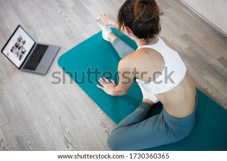 oung sporty slim woman has internet video online fitness training instructor modern laptop screen. Healthy lifestyle concept, online fitness and sport lessons. Stretching online. Royalty-Free Stock Photo #1730360365