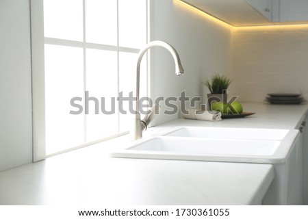 New ceramic sink and modern tap in stylish kitchen interior Royalty-Free Stock Photo #1730361055