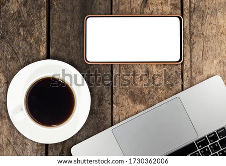 Laptops and smartphones with coffee on old wooden floors.