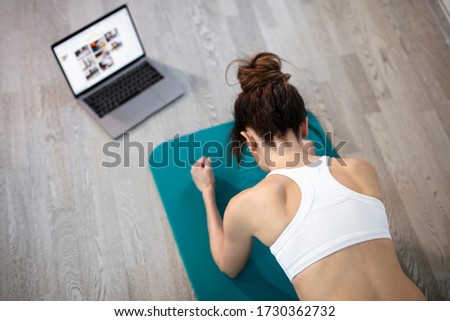 oung sporty slim woman has internet video online fitness training instructor modern laptop screen. Healthy lifestyle concept, online fitness and sport lessons. Plank exercise Royalty-Free Stock Photo #1730362732