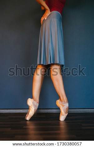 Legs of ballerinas in pointe shoes, on dark background, close-up