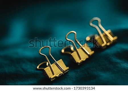 Closeup macro photo of golden office pin. Conceptual picture with group and one apart from all