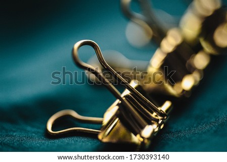 Closeup macro photo of golden office pin. Conceptual picture with group and one apart from all
