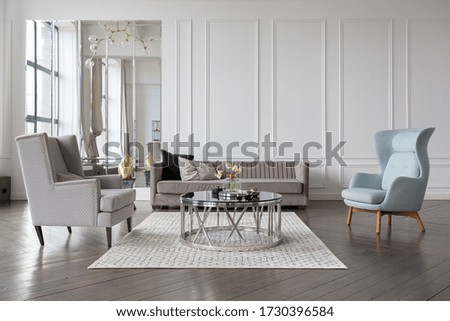 Modern luxury stylish apartment interior in pastel colors. a very bright room with huge windows filled with daylight. white walls, wooden parquet floors and a dark marble fireplace Royalty-Free Stock Photo #1730396584