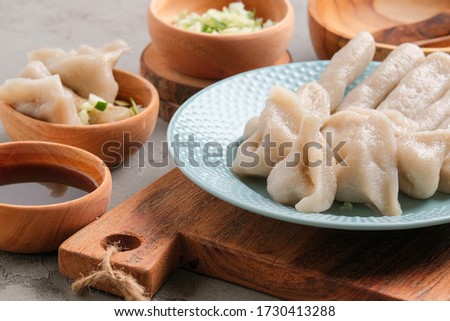 pempek served on grey unfinished cement table. Pempek is traditional food from indonesia. made of fish and tapioca served with rich sweet and special sour sauce or vinegar sauce called cuka