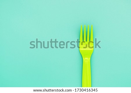 green fork on green background. eco food concept.