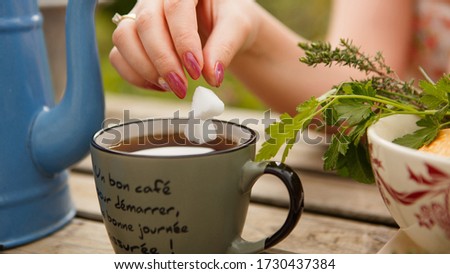 concept of Breakfast and teatime in open air. sugar cubes in shape of hearts. Tea into mug (inscription on French: good coffee to start with, I have good day) picnic in countryside. morning Provence.