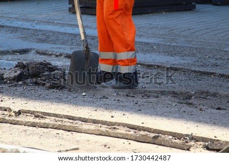 Workers remove the old pavement for laying new asphalt. Road repair