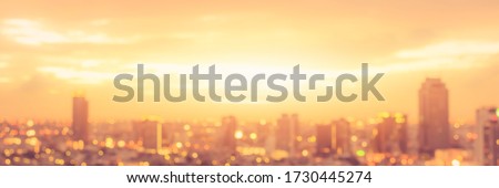 Rooftop party blur city background of blurry sunrise or happy golden hour sunset evening with heatwave, sunmmer sun heat wave, and cityscape buildings skyline backdrop for June Solstice  Royalty-Free Stock Photo #1730445274