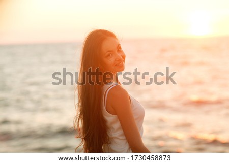 girl at sunset by the sea smiling