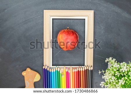 Red apple in the picture frame, pencil color against chalk board, art creative concept.