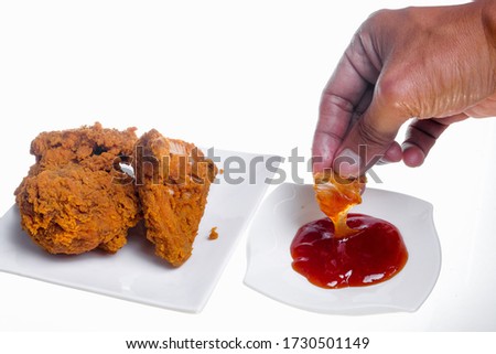 Hand holding fried chicken on white background