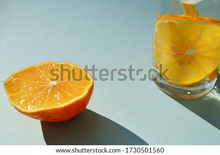 lemon water with ice in a glass glass with lemon in a glass and in the foreground on a mint background close-up