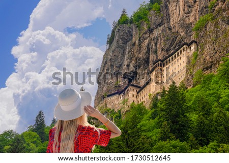 Tourist woman watches Sumela Monastery in Trabzon, Turkey. Sumela Monastery is one of the best tourist attraction in Black Sea region of Turkey. Royalty-Free Stock Photo #1730512645