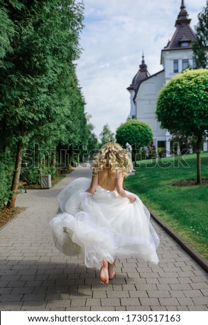 Portrait of a beautiful blonde bride. A woman runs away from her wedding. Royalty-Free Stock Photo #1730517163