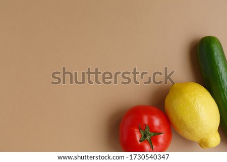 Fresh fruits and vegetables. Healthy nutrition and diet. Lemon, tomato and cucumber on a light solid background