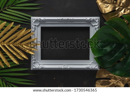 Creative layout with gold and green tropical palm leaves with white frame on black background. Minimal summer abstract pattern.