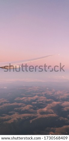 Picture of the sunset and the mountain under the sky during a travel in plane above the USA