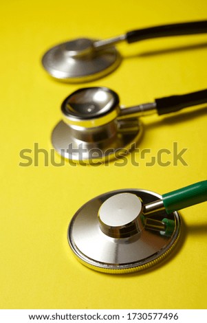 Three stethoscopes on a yellow table