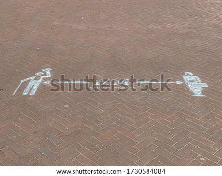 Due to Coronavirus disease (COVID-19) scourge, White painted on brick footpath, Symbol on the ground "KINDLY PLEASE 1,5 M" Reminding people to keep away from each other, Social or physical distancing.