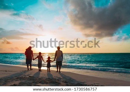 happy family with tree kids walk at sunset beach