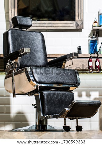 Professional hairstylist in barbershop interior. Barbershop interior. Barber shop chair. Barbershop armchair, modern hairdresser and hair salon, barber shop for men. Stylish vintage barber chair.