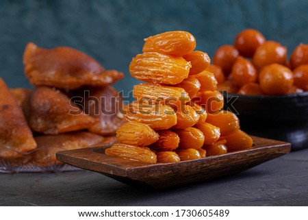 Arabic Cuisine: Middle Eastern traditonal dessert/Ramadan dessert "Balah Al-Sham" or "Balah El Shaam" served with honey syrup and pistachio. Close up with copy space. Royalty-Free Stock Photo #1730605489