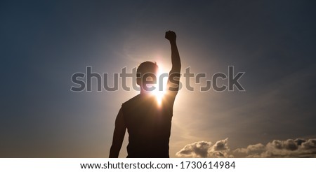 People, strength, power, and never giving up concept. Strong man with fist up to the sky.  Royalty-Free Stock Photo #1730614984