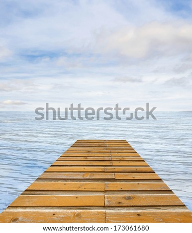 wooden pier on sunny day with white clouds and sun