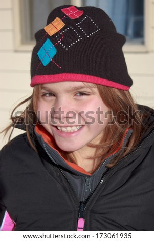 Young girl in a winter hat and coat smiling
