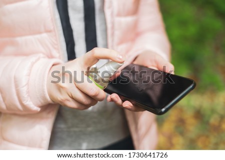 How to clean, sanitize your phone. Cleaning mobile phone to eliminate germs, coronavirus Covid-19. Hands cleaning smartphone by disinfectant napkin. Hygiene concept