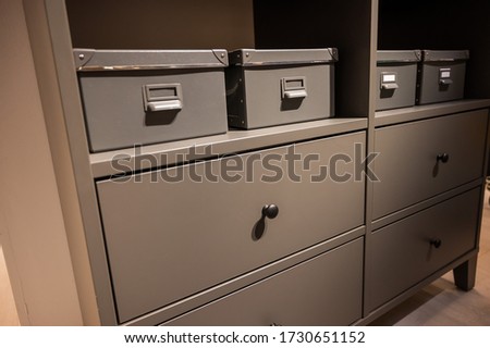 Closeup of a gray chest of drawers. A variant of simple furniture without decor and design in the interior.