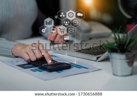 Businesswoman using a calculator with computer laptop at office on digital interface. innovation, icon and media information network connection, work from home.