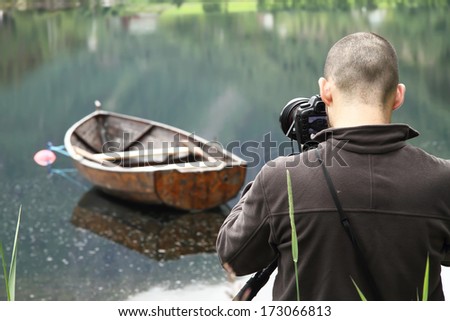 Nature photographer taking a picture of a boat in Norway