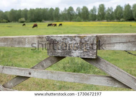 Sign Private on wooden gate in front of green rural field. Farm, farm field, family local English business.  Photo made on May 2020 Royalty-Free Stock Photo #1730672197