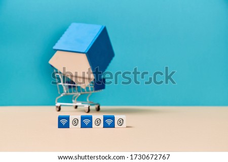 Online rent. Booking accommodation. House for sale. Wooden block with coin and wifi sign. Mockup style. House miniature