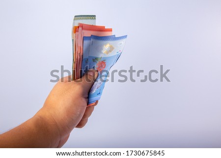 Man Hand Holding Malaysia Bank Notes on White Background.