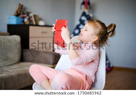 Caucasian child watching online video and cartoons on digital tablet, preschool girl playing computer games, schoolgirl doing homework and making video call with teacher on application. Self education