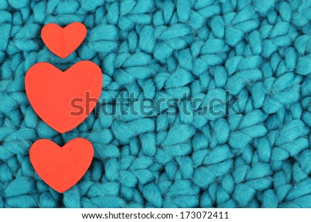 Hearts made of felt on green knitted background