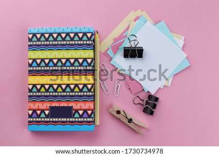 Beautiful notebook for notes, paper clip on pink background