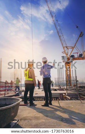 Structural engineer and foreman worker with touch pad discuss, plan working for the outdoors building construction site. Royalty-Free Stock Photo #1730763016