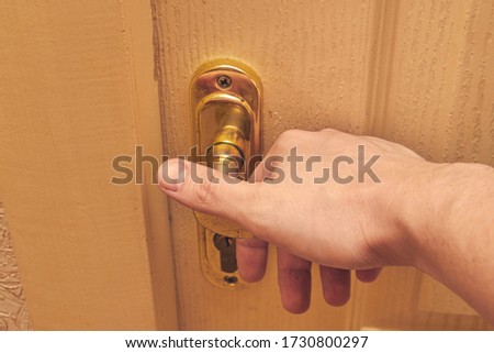 hand on a golden shaded doorknob opens, closes. close up