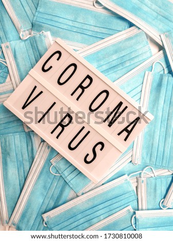 Blue surgical face masks with a white light box stating Coronavirus