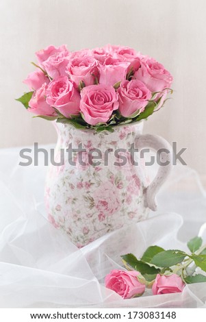 	fresh pink roses in a beautiful ceramic vase