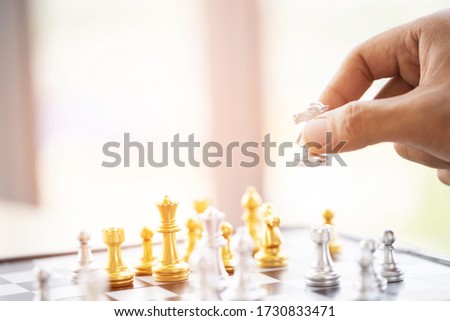 close up hand player silver chess horse moving on a chess board game fallen golden color tone victory success. strategy ideas Planning and Decision concept business leader.