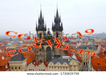 Coronavirus in Prague, Czech Republic. The gothic Church of Mother of God in front of Tyn in Old Town Square. Covid-19 sign on a blurred background. Concept of COVID pandemic and travel in Europe.