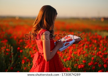 girl in a poppy field draws a picture