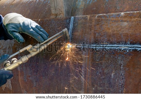 The worker is cutting steel plate with oxy-acetylene cutting processes for mechanical test. Royalty-Free Stock Photo #1730886445