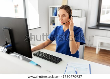 medicine, technology and healthcare concept - female doctor or nurse with headset and computer working at hospital Royalty-Free Stock Photo #1730970937